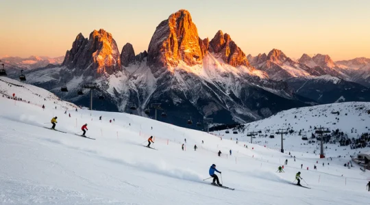 Vista panoramica delle Dolomiti del Trentino con sciatori che scendono piste innevate durante una giornata soleggiata, evidenziando l'accessibilità del comprensorio sciistico