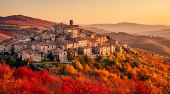 Vista panoramica di un borgo italiano con colline dorate al tramonto