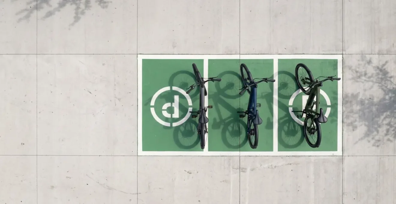 Vista dall'alto di e-bike parcheggiate correttamente in area designata con segnaletica astratta